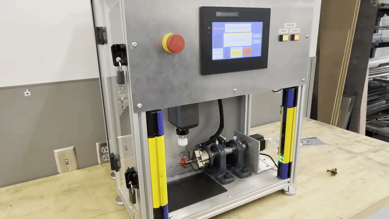 [GIF] an ORCA™ Smart Linear Motor is shown pressing down on a routed bit inside a clear safety enclosure.