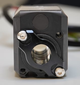 Front view of an ORCA motor showing the black bushing retainer installed around the shaft opening and secured with two bolts