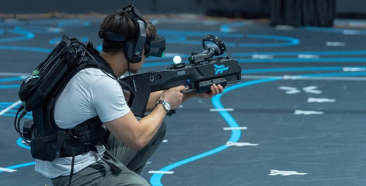 A man wearing a VR headset aims a laser gun demonstrates the advantages of virtual reality in entertainment.